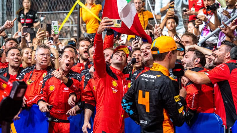 Carlos Sainz poses for a selfie with Ferrari crew after winning 2023 F1 Singapore Grand prix