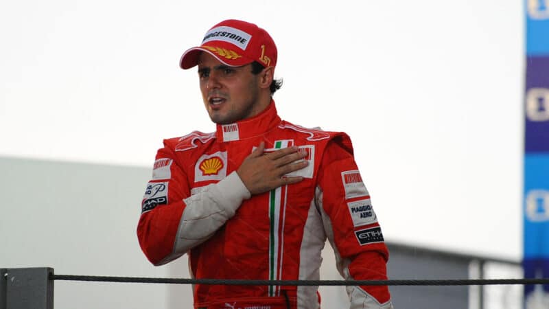 Felipe Massa holds his hand against his heart on the podium after winning 2008 Brazilain Grand Prix but losing the F1 championship