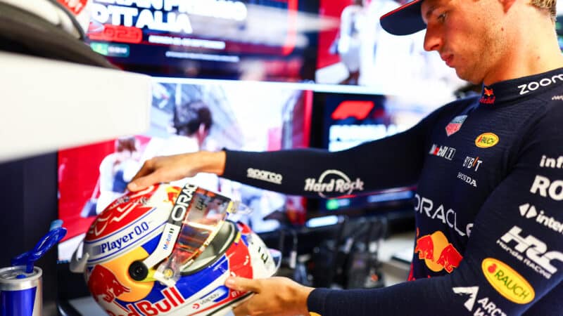 Max Verstappen examines his crash helmet ahead of 2023 F1 Italian GP