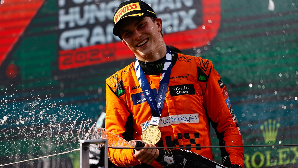 Oscar Piastri sprays champagne on the F1 podium after winning 2024 Hungarian Grand Prix