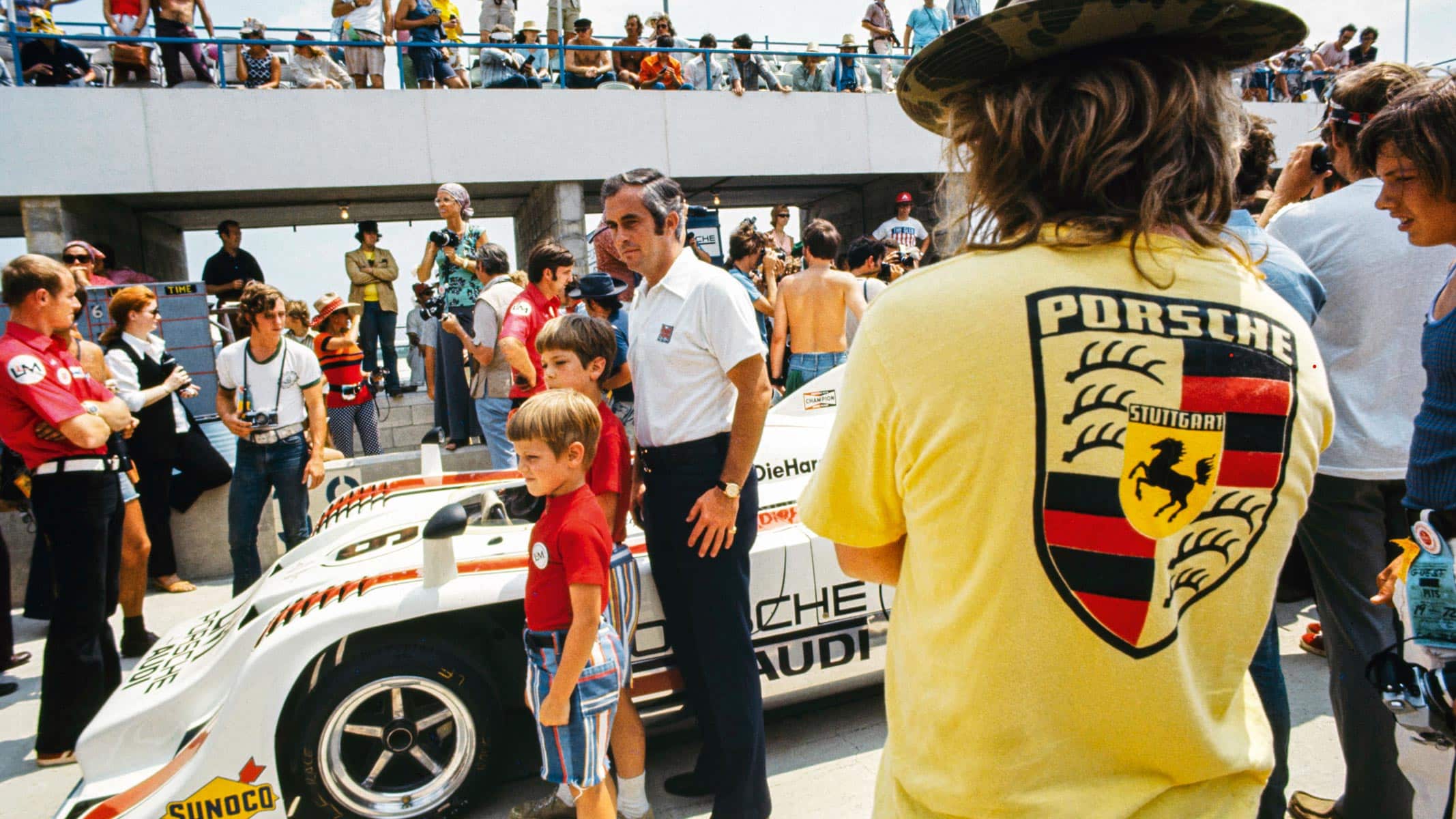 Roger Penske posing with a couple of young fans