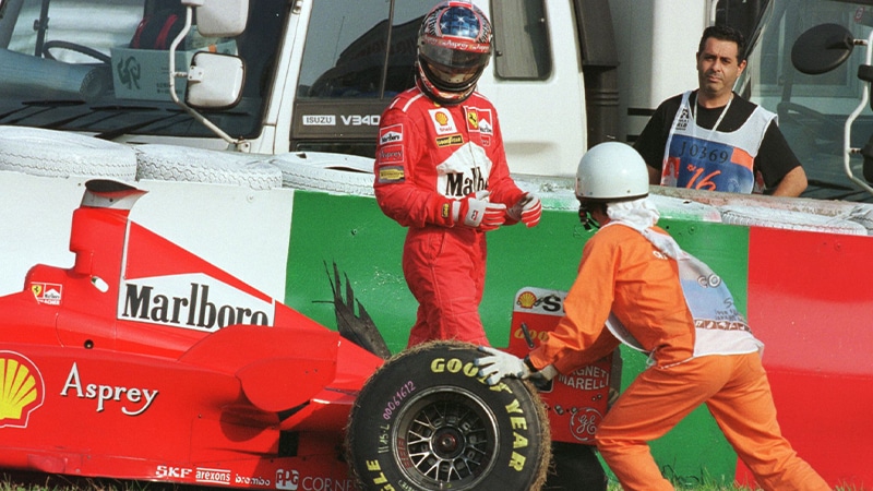 Michael Schumacher walks away from his Ferrari after retiring from the 1998 Japanese Grand Prix