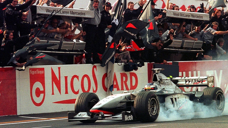 Mika Hakkinen drivers past MclAren pit in a cloud of smoke as he wins the 198 Japanese GP and F1 world championship