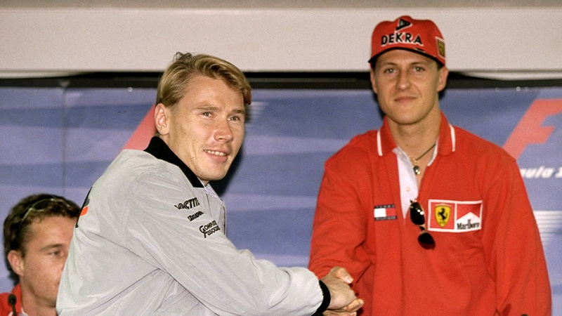 Mika Hakkinen shakes hands with michael Schumacher ahead of the 1998 Japanese Grand Prix