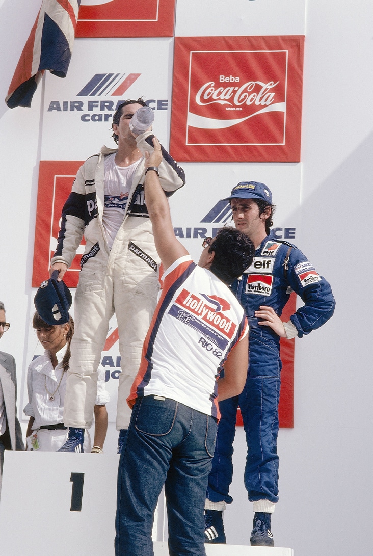 Nelson Piquet drinks water on podium after 1982 Brazilian GP