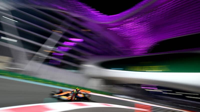 Blurred McLaren of Lando Norris at night on Yas Marina circuit