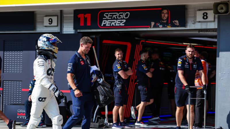 Daniel Ricciardo looks into the pitbox of Sergio Perez