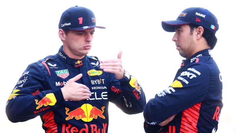 Max Verstappen gestures with his hands while talking to Sergio Perez at the 2023 Abu Dhabi Grand Prix