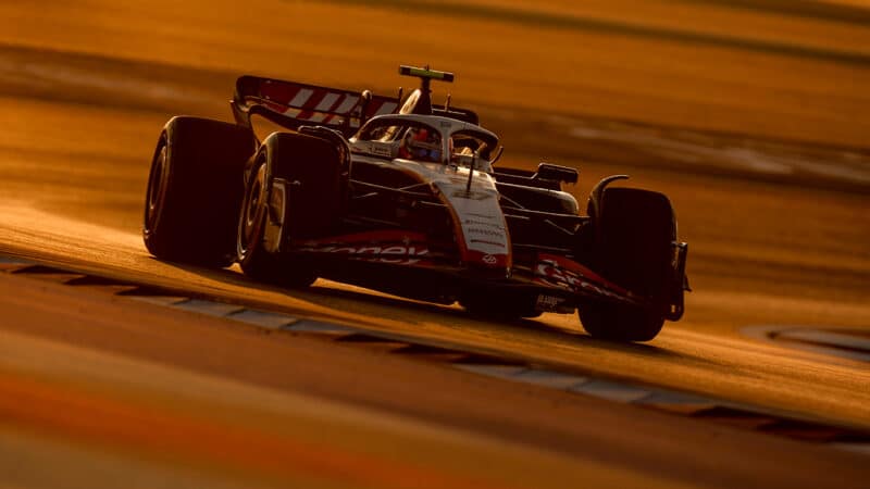 Haas of Kevin Magnussen drivin in sunset at 2023 Qatar GP