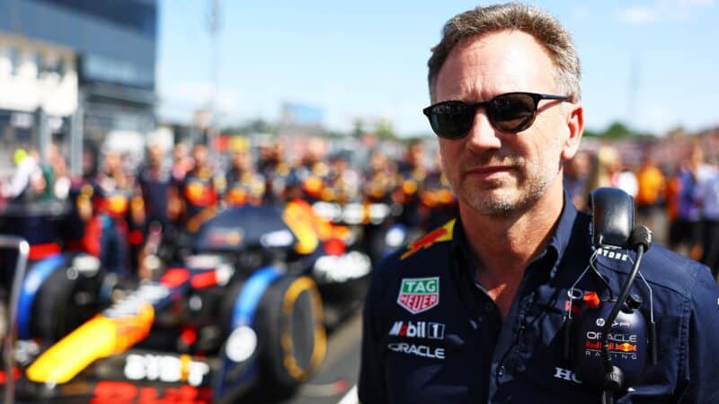 Christian Horner in sunglasses in front of Red Bull car on F1 grid