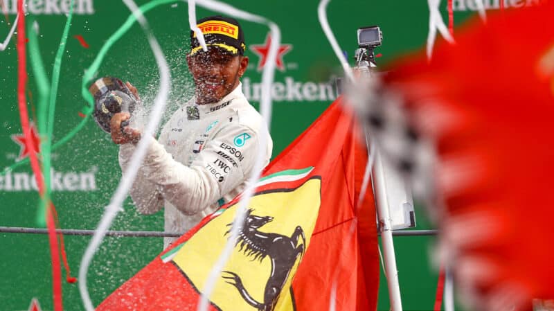 Lewis Hamilton sprays champagne in front of Ferrari flags at 2018 Italian Grand Prix at Monza