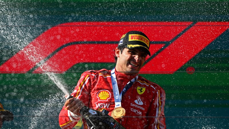 Carlos Sainz celebrates Australian GP victory spraying champagne on Melbourne podium