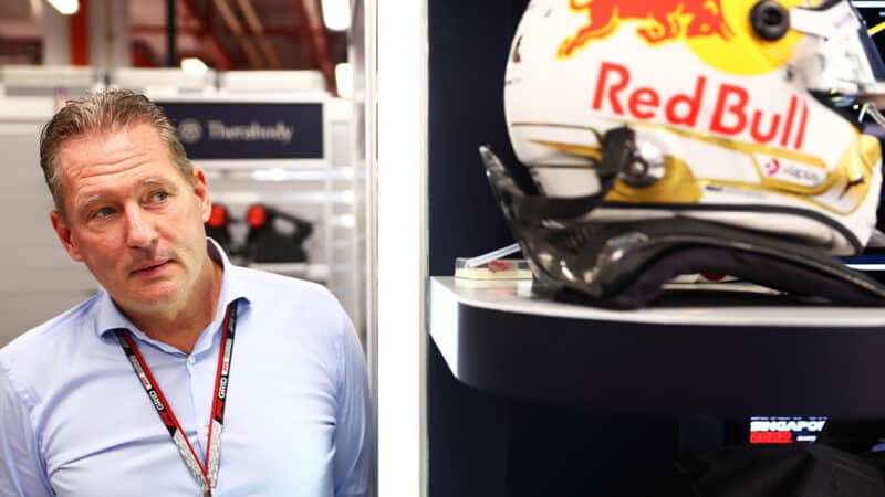 Jos Verstappen looks at Max Verstappen helmet in Red Bull F1 pit garage