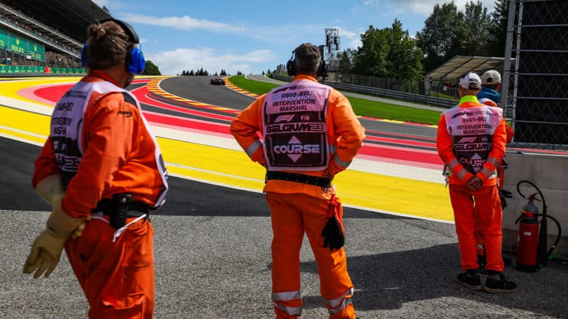 Marshals watch F1 cars at Eau Rouge during 2023 Belgian Grand Prix weekend