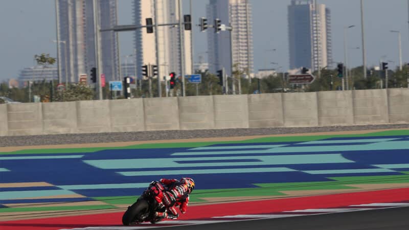 MotoGP rider on track in front of skyscrapers at Losail circuit