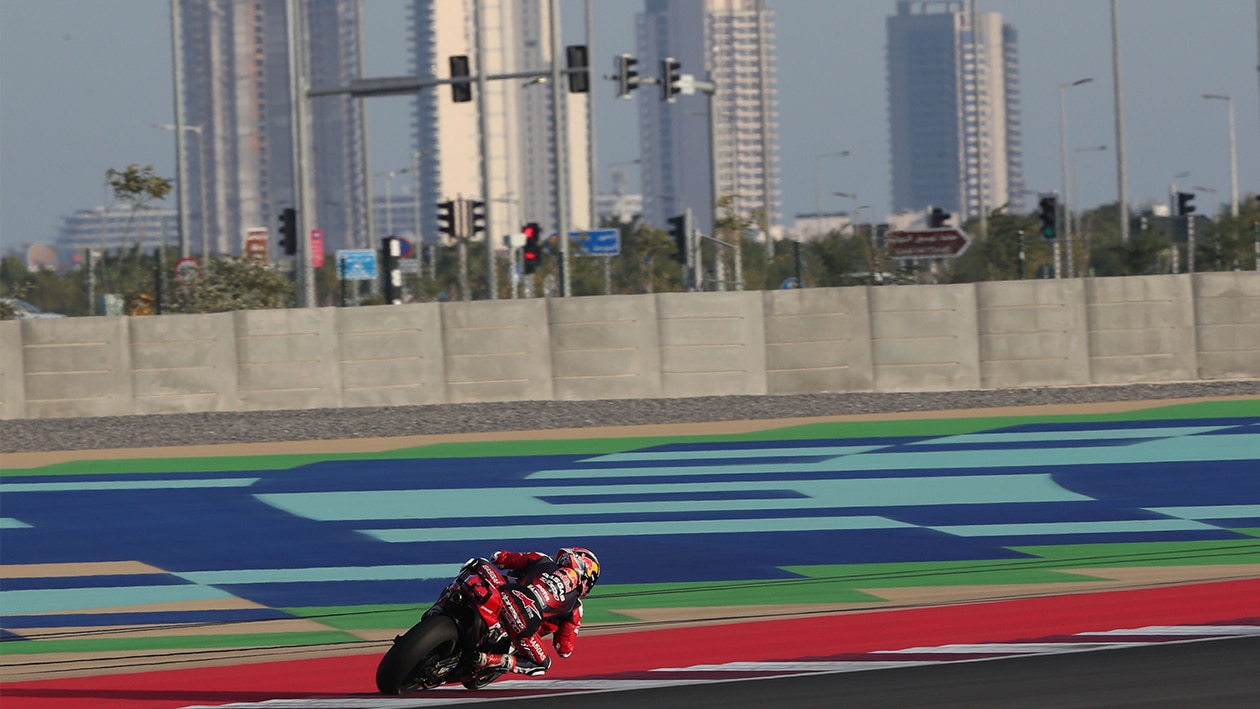 MotoGP rider on track in front of skyscrapers at Losail circuit