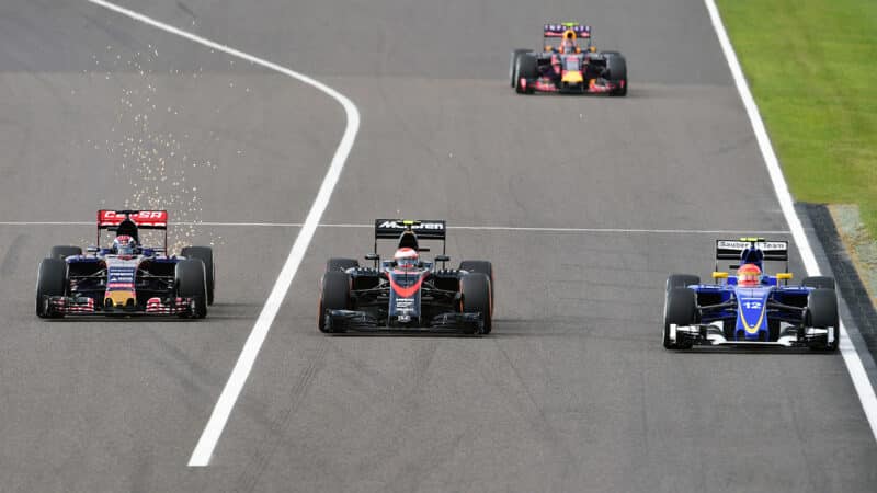 Toro Rosso of Max Verstappen and Sauber of Felipe Nasr either side of Jenson Button in 2015 Japanese GP