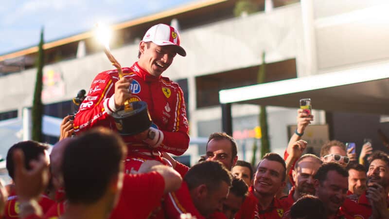 Charles Leclerc surrounded by Ferrari F1 team holding 2024 Monaco Grand Prix winners trophy