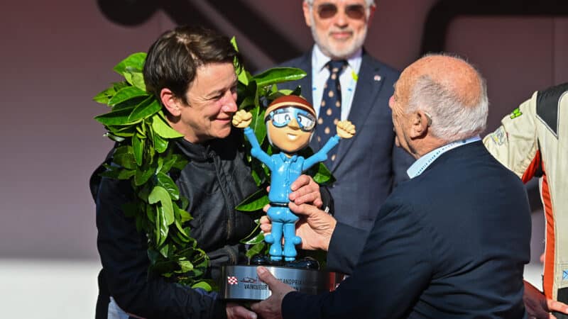 Claudia Hurtgen is handed the winners trophy after victory in the 2024 Historic Monaco GP
