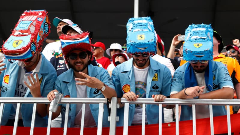 Ferrari fans with hats in the shape of cars in 2024 F1 Miami GP crowd