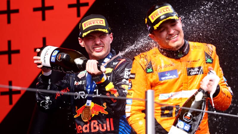 Max Verstappen sprays Lando Norris with champagne on the podium after 2024 F1 Emilia Romagna GP