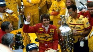 Rick Mears with car and Borg Warner Trophy celebrates winning 1984 Indy 500