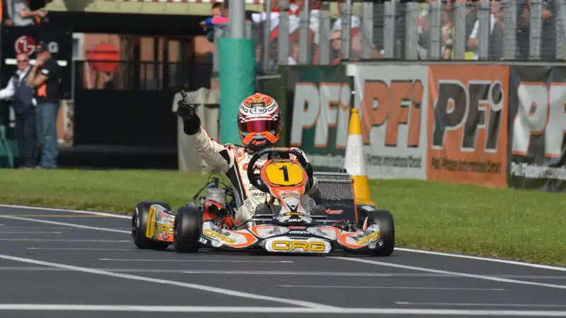 Max Verstappen raises his hand after karting win