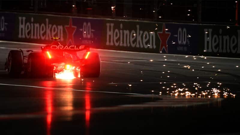 Sparks and red light from rear of Sergio Perez Red Bull at 2023 Las Vegas Grand Prix