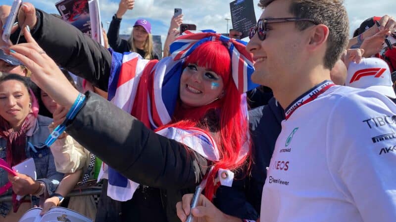 George Russell takes a selfie with a fan at the F1 British Grand Prix