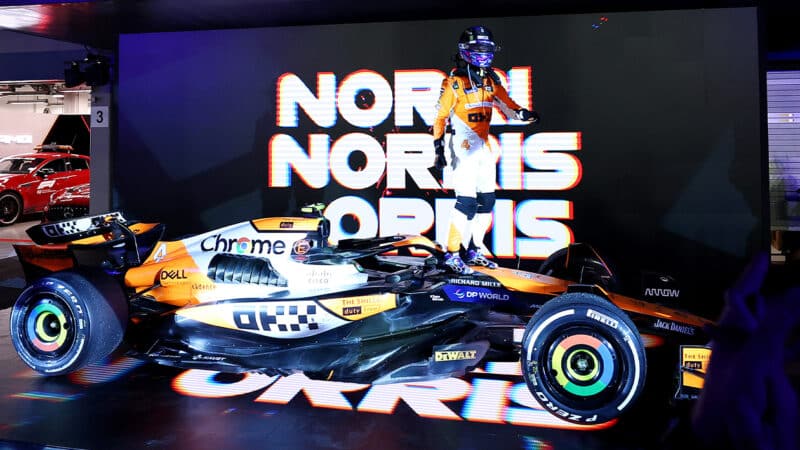 Lando Norris standing on his F1 car celebrating his win in the 2024 Singapore Grand Prix