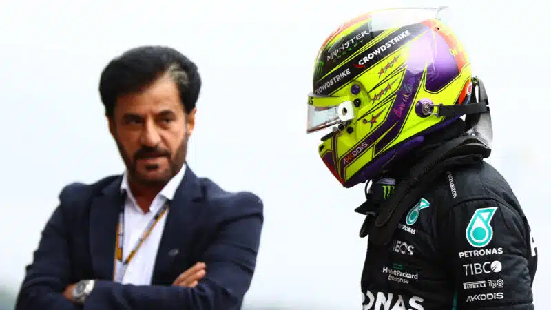 Mohamed Ben Sulayem looks at Lewis Hamilton with arms crossed