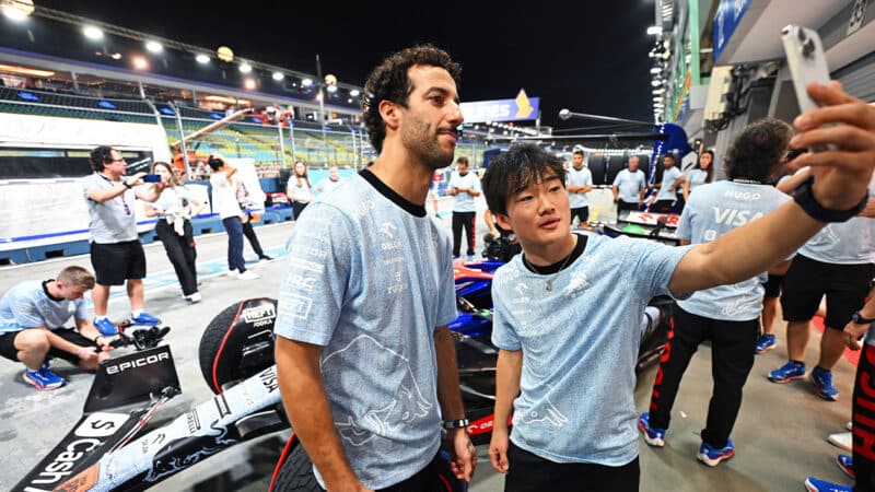 Yuki Tsunoda takes a selfie with Daniel Ricciardo in front of the RB F1 pit garage in Singapore