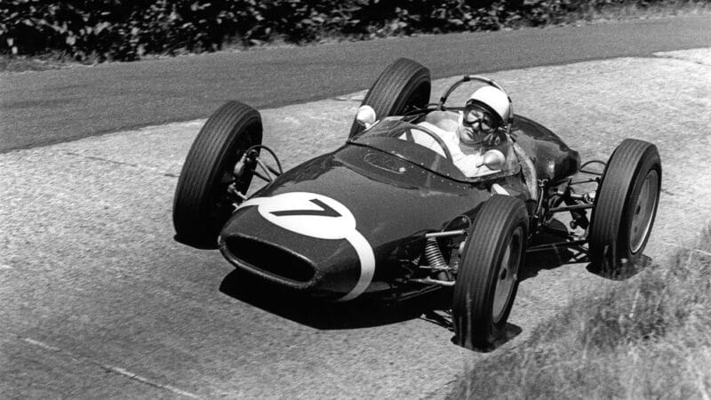 Moss, with concentration etched on his face, driving the Lotus-Climax in 1961. This would be one of his great drives