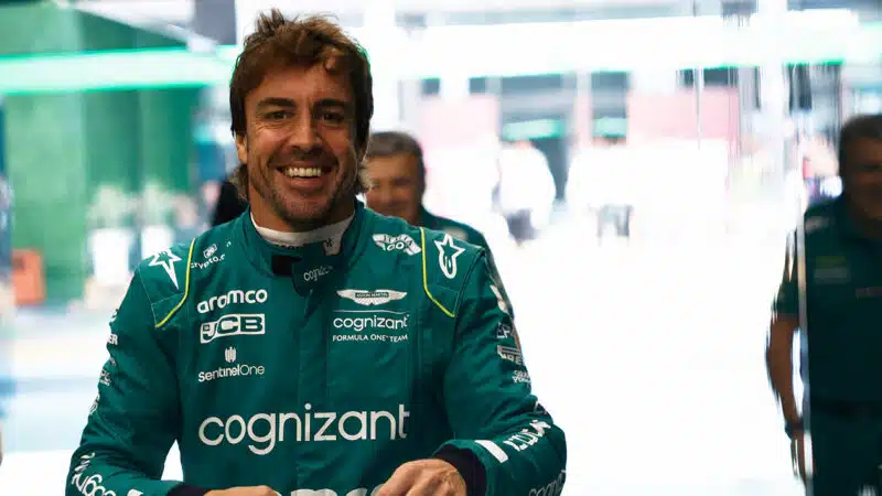 Fernando Alonso smiles in Aston Martin F1 pit garage