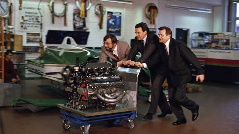 Hans-Joachim Esch, Helmut Flegl and Hans Mezger push an engine through the factory in 1990