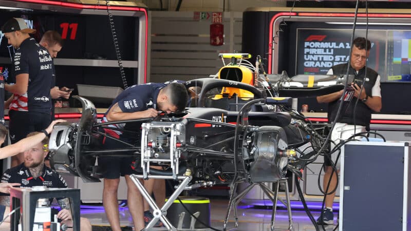 Mechanics work on Red Bull F1 car in pits at 2024 United States GP