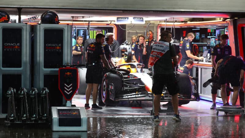 Red Bull F1 car in pit garage as rain falls at the 2023 Brazilian Grand Prix