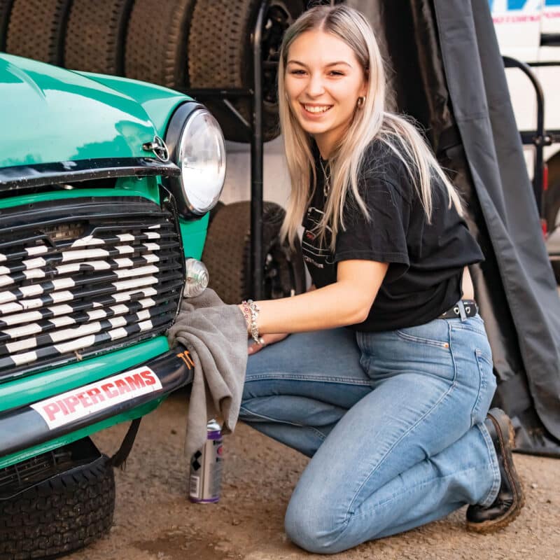 Woman working on car and a smile