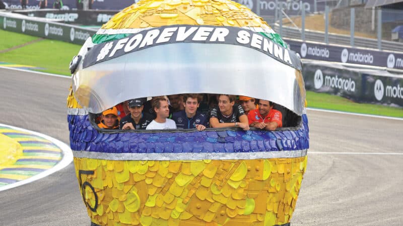 drivers in an Ayrton Senna tribute giant helmet