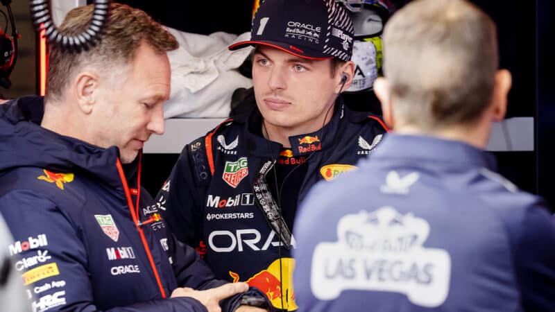 Christian Horner checks his watch while standing next to Max Verstappen at 2023 F1 Las Vegas Grand Prix