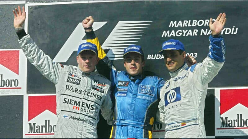 Fernando Alonso on 2003 F1 Hungarian Grand Prix podium with Kimi Raikkonen and Juan Pablo Montoya