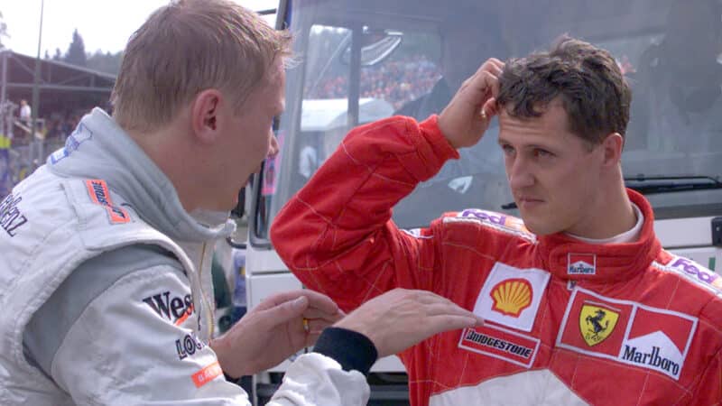 Mika Hakkinen speaks to stern looking Michael Schumacher after 2001 F1 Belgian Grand Prix