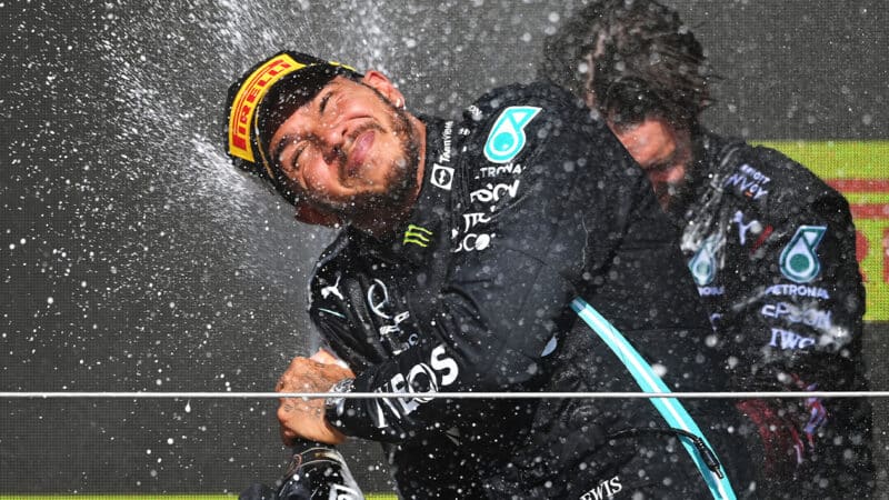 Lewis Hamilton sprays champagne on the podium after winning 2021 F1 British Grand Prix