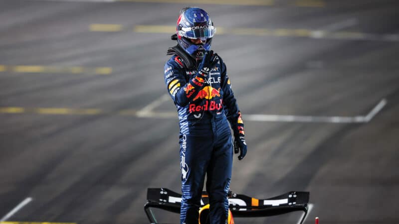 Max Verstappen holds up 4 standing on car