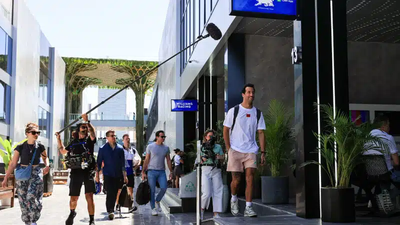 Daniel Ricciardo smiles as he's filmed by Netflix Drive to Survive cameras in the F1 paddock