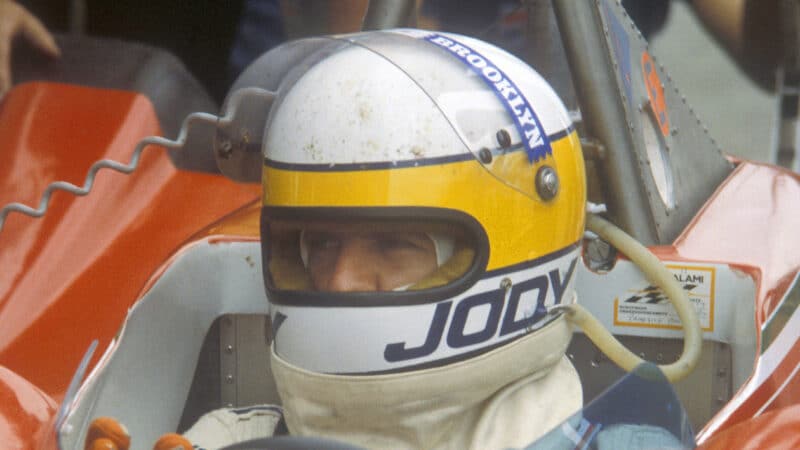 Jody Scheckter with helmet on in F1 ferrari cockpit