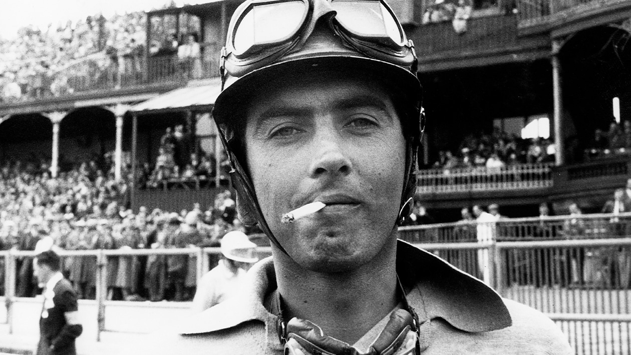 Luigi Musso smoking at the 1957 British Grand Prix