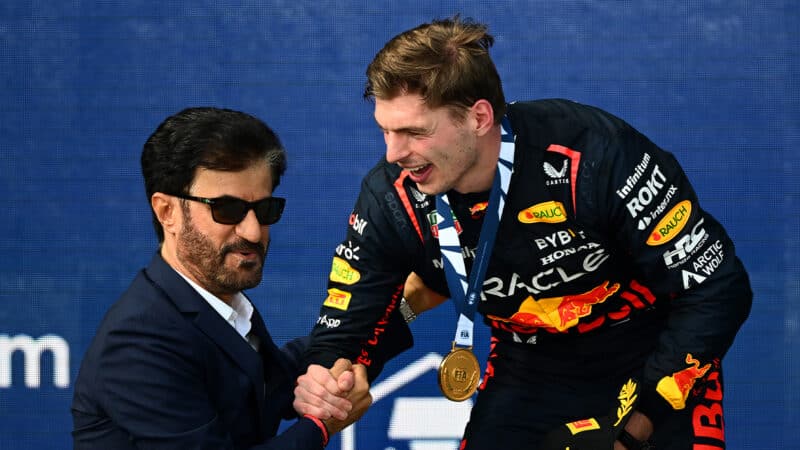 Max Verstappen laughs as he shakes the hand of Mohammed Ben Sulayem