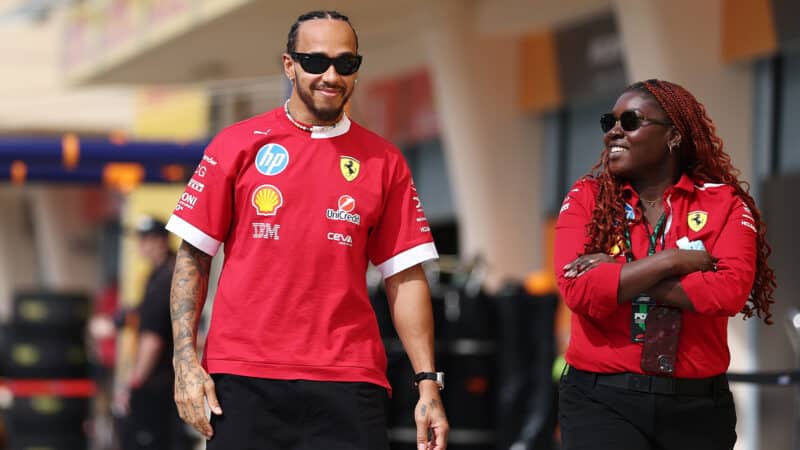 Lewis Hamilton smiles as he walks down the pitlane in 2025 F1 preseason testing