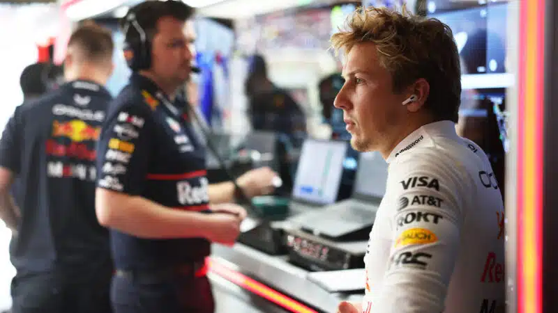 Liam Lawson sits in thought in the Red Bull F1 pit garage